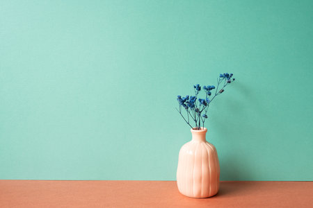 Vase of dry blue gypsophila flower on red table. mint green wall backgroundの写真素材