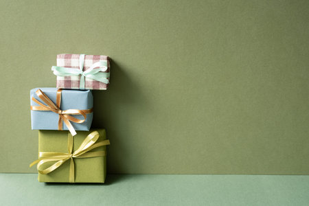 Stack of gift boxes on green table. Khaki wall background. anniversary celebration concept