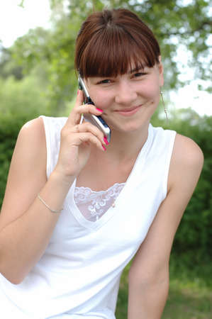 Smiling young female speaking on mobile phoneの写真素材