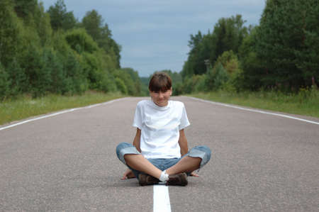 Young woman sitting on center mall of the roadの写真素材