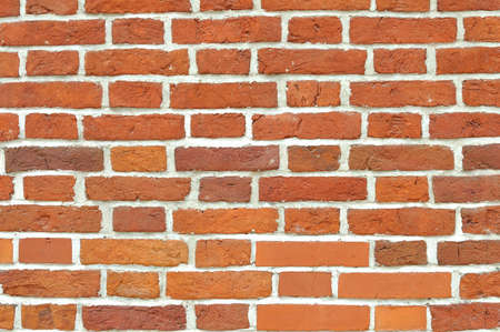 Red brick wall built of different stones. Can be used as backgroundの写真素材