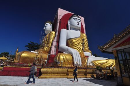 Bago,Myanmar - 29 November 2015: Unknown tourists are praying at Kyaik Pun Pagoda, Pagoda of four giant Buddha statues in Bago, Myanmar.のeditorial素材