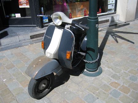 Scooter chained to Lamp postの写真素材