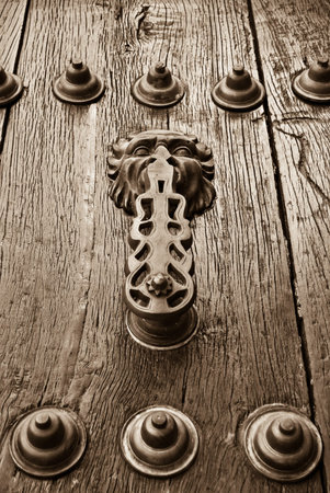doorknob with gargoyle on old wooden door in Ronda, Malaga, Spain