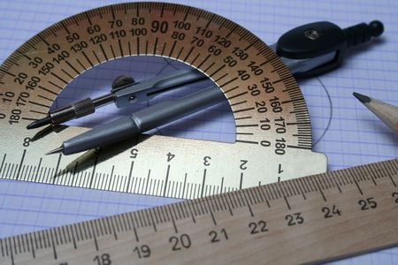 Compasses, pencil and rulers on squared paperの写真素材