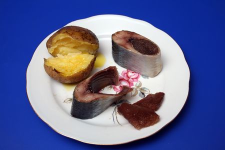sliced herring, cavair and potato on a plateの写真素材