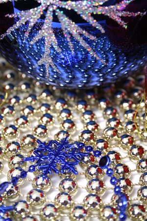 Glass christmas sphere and snowflake of dark blue color on a background made of a beads の写真素材