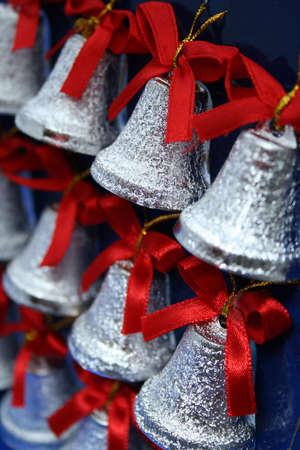 Christmas handbells of silvery color with red bows の写真素材