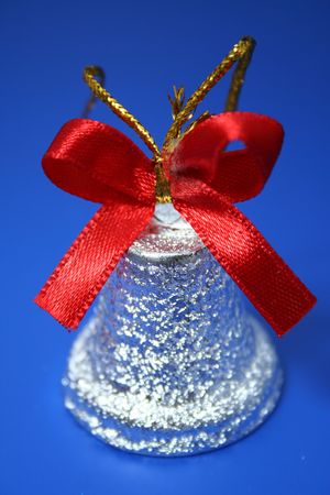 Christmas handbell of silvery color with a red tape on a dark blue background の写真素材