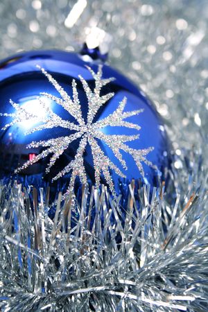 New Year's glass sphere of dark blue color with a pattern on a background of a christmas tinselの写真素材