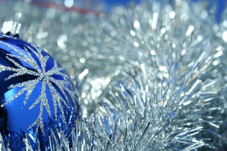 Christmas glass sphere of dark blue color with a pattern on a background of a celebratory tinsel の写真素材