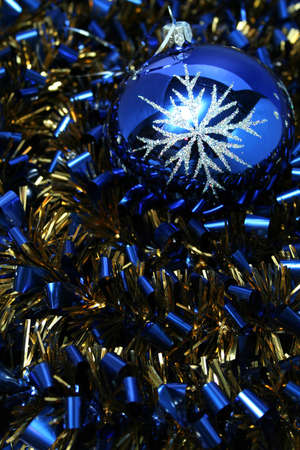 Christmas glass sphere with a pattern on a background of a celebratory tinsel of dark blue color の写真素材