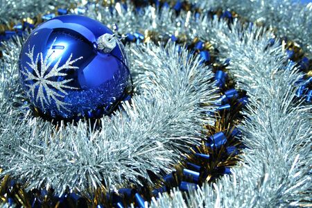 Christmas glass sphere with a pattern on a background of a brilliant celebratory tinsel of two colors の写真素材