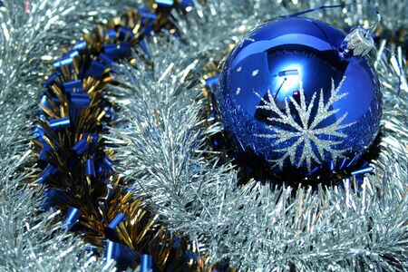 Christmas glass sphere with a pattern on a background of a brilliant New Year's tinsel of two colorsの写真素材