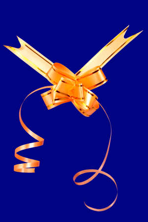 Gift bow of yellow color on a blue background の写真素材