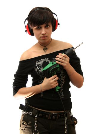 The young girl with headphones and a building drill in hands の写真素材
