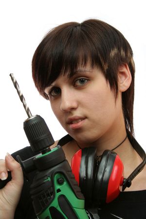 The young girl with headphones and a building drill in hands の写真素材