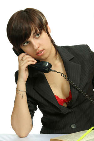 The young nice girl speaks by phone, isolated on whiteの写真素材