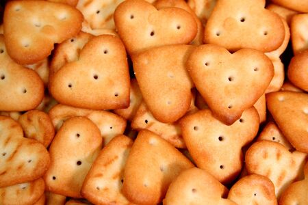 Heart made of a cracker on a background of others cookiesの写真素材