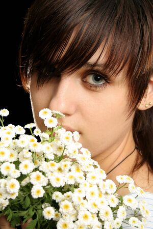 The young beautiful girl with flowers, isolated on a black backgroundの写真素材