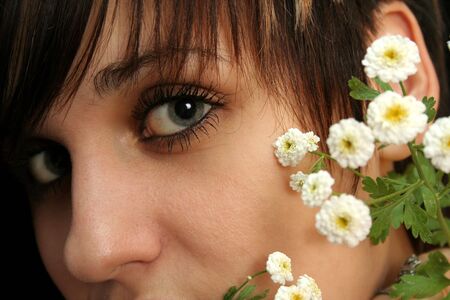 The young beautiful girl with flowers, isolated on a black backgroundの写真素材