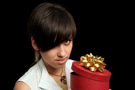 The young girl holds a box with a gift, isolated on black backgroundの写真素材