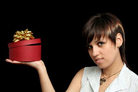 The young girl holds a box with a gift, isolated on black backgroundの写真素材