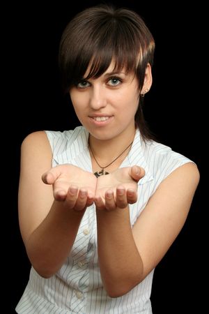 The young girl holds something in a hands, is isolated on a black backgroundの写真素材