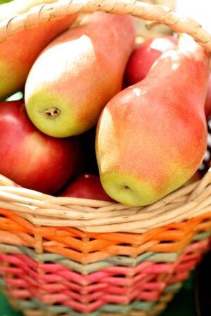 Ripe fresh pears in a basket, backgroundの写真素材