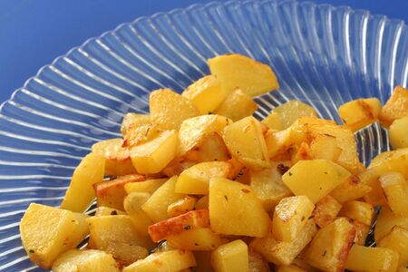 Fried potatoes in a glass plate on blueの写真素材