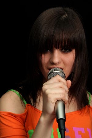 Girl with a microphone on black backgroundの写真素材