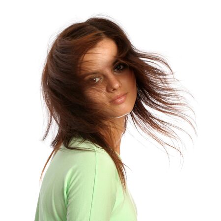 Young brunette girl with a hairdress in movement, isolated on whiteの写真素材