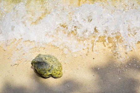 Coral rock with sea wave splashing on Thailand sandy beach, Samui islandの写真素材