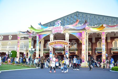 Tourist around the world visiting Tokyo Disneyland in the event of Tokyo Disney Resort 35th Happiest Celebration. The entrance of the park decorated in colorful themeのeditorial素材