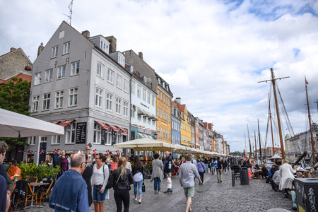 Locals and tourists are spending their time visiting Nyhavn, a very popular waterfront, canal and entertainment district in Copenhagen, Denmarkのeditorial素材