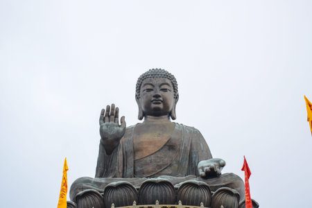 The enormous Tian Tan Buddha sitting on lotus statue up on high mountain near Po Lin Monastery,...