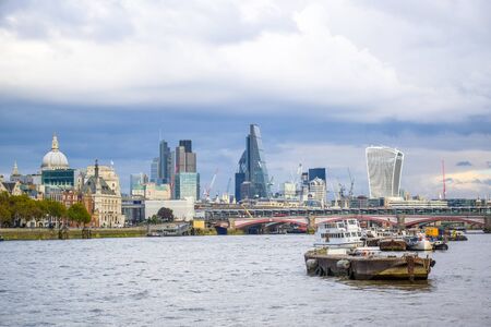 Cityscape view of River Thames with ships in foreground and high buildings in background in London, England, United Kingdomのeditorial素材