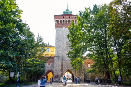 Tourists and locals spending their time at St. Florian's Gate, the Polish gothic city defense walls with medieval towers and a focal point of Krakow's Old Town, Polandのeditorial素材