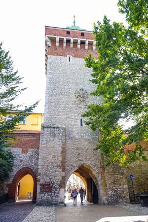 Tourists and locals spending their time at St. Florian's Gate, the Polish gothic city defense walls with medieval towers and a focal point of Krakow's Old Town, Polandのeditorial素材