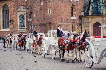 Traditional horse drawn carriage riding vehicle serving tourists around Krakow's Main Square (Rynek Glowny), the most popular tourist activity in Krakow, Polandのeditorial素材