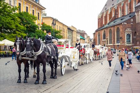 Traditional horse drawn carriage riding vehicle serving tourists around Krakow's Main Square (Rynek Glowny), the most popular tourist activity in Krakow, Polandのeditorial素材