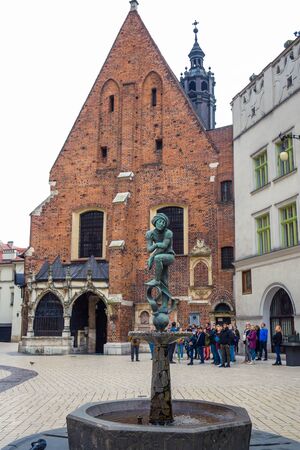 A polish statue fountain in front of St. Barbara church located at Main Square of Krakow, Polandのeditorial素材