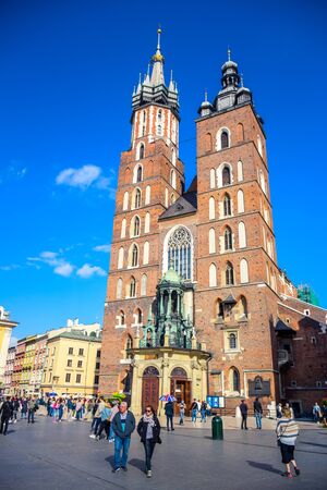Tourists visiting St. Mary's Basilica, an ancient brick Gothic Polish church adjacent to Main Town Square in Krakow, the most famous tourist destination in Polandのeditorial素材