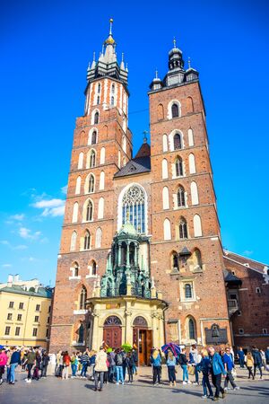 Tourists visiting St. Mary's Basilica, an ancient brick Gothic Polish church adjacent to Main Town Square in Krakow, the most famous tourist destination in Polandのeditorial素材
