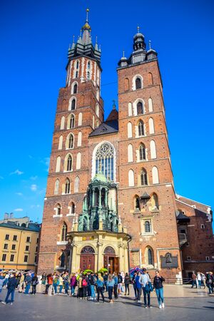 Tourists visiting St. Mary's Basilica, an ancient brick Gothic Polish church adjacent to Main Town Square in Krakow, the most famous tourist destination in Polandのeditorial素材