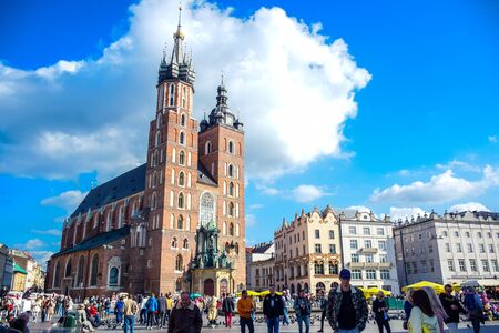 Tourists visiting St. Mary's Basilica, an ancient brick Gothic Polish church adjacent to Main Town Square in Krakow, the most famous tourist destination in Polandのeditorial素材