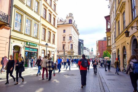 Tourists and Polish locals enjoying their time walking along the street in the city of Krakow, Polandのeditorial素材