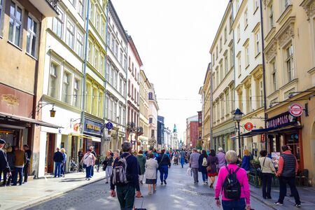Tourists and Polish locals enjoying their time walking along the street in the city of Krakow, Polandのeditorial素材