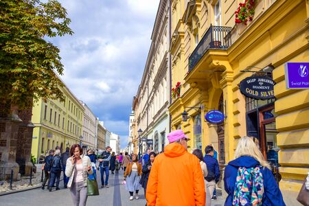 Tourists and Polish locals enjoying their time walking along the street in the city of Krakow, Polandのeditorial素材