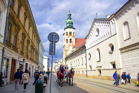 Tourists and Polish locals walking and strolling on the street in the city of Krakow, Polandのeditorial素材